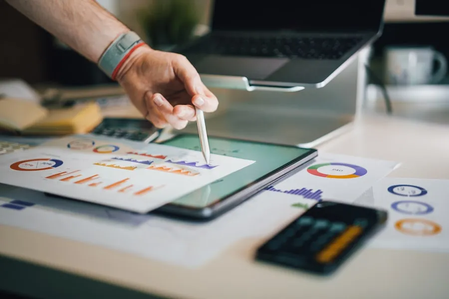 A hand marking up printed charts on a desk