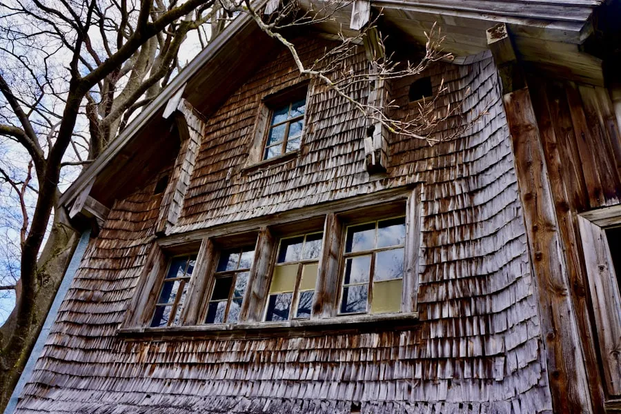The Brooklin house before, with peeling paint on cedar siding