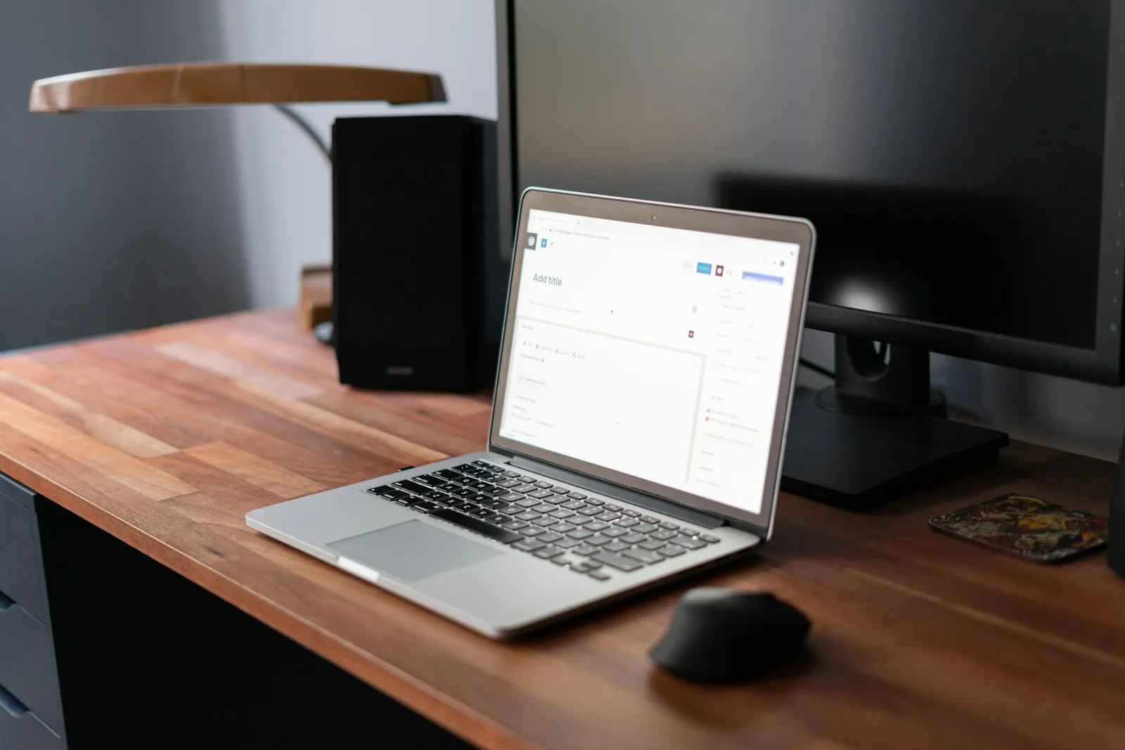 A laptop on a wooden desk showing a content editing screen