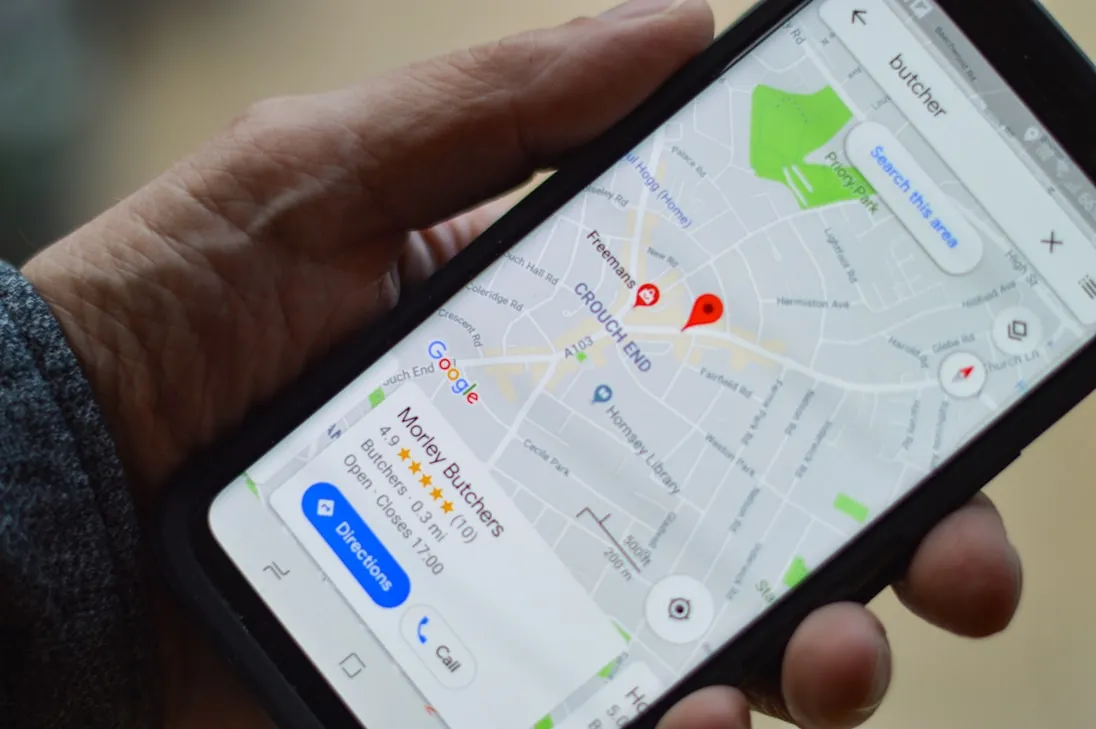 A phone showing a map app with a local business pinned, rated and open