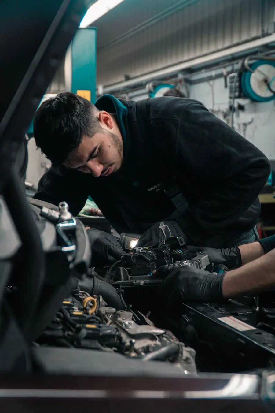 A licensed technician working under a raised vehicle at Redline Auto Service