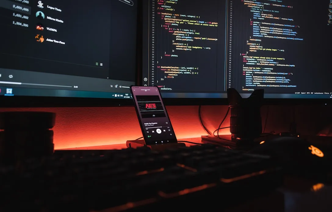 A developer workstation at night with code open on a wide monitor